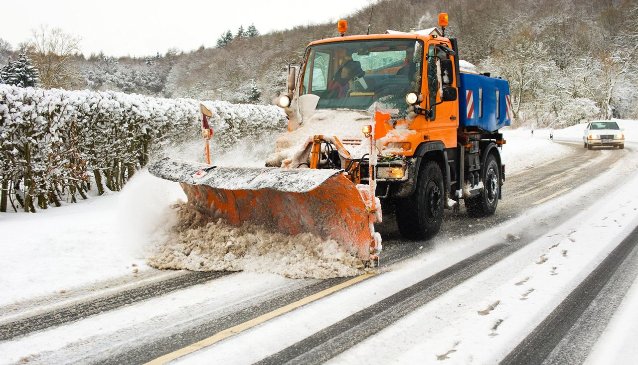 Räumfahrzeug mit Schneepflug auf einer verschneiten Straße